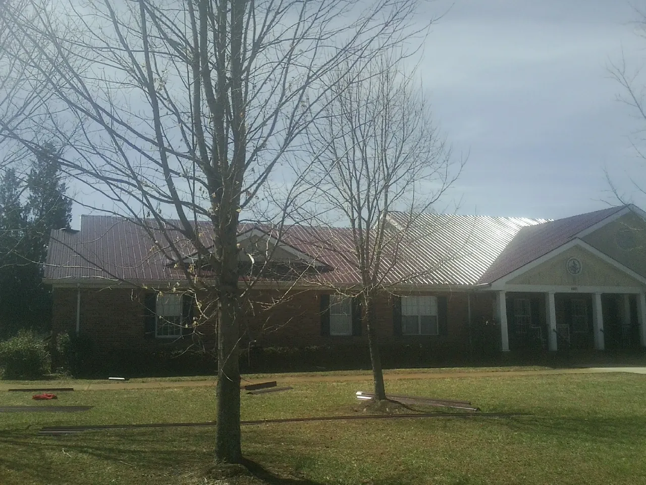 Red metal roof on a brick building seen from the front lawn in Salisbury