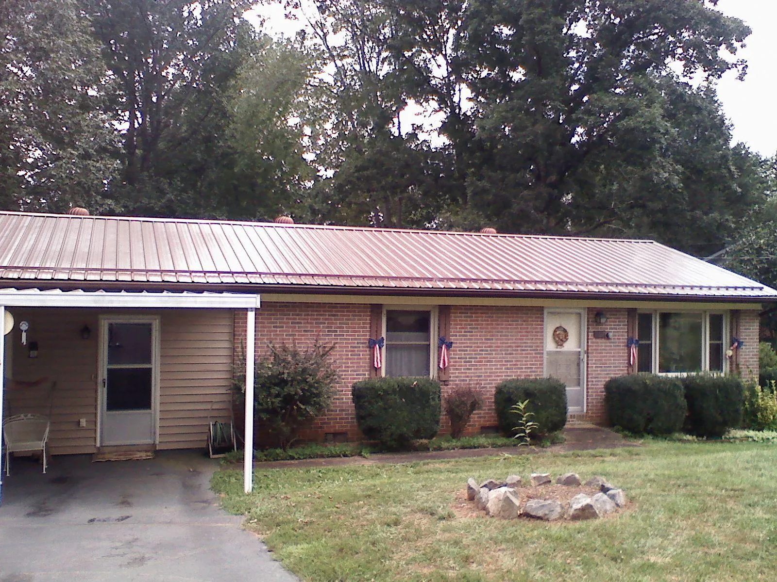 Bronze metal roof and carport on a brick ranch home — Roof Repair work by our crew in Salisbury
